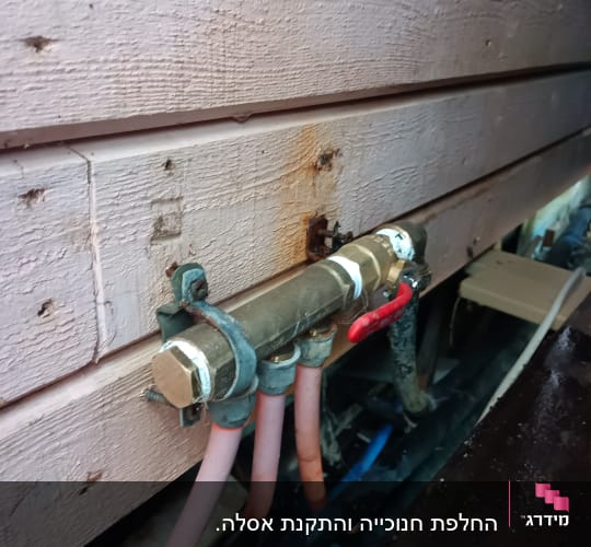צינורות מים מחוברים לשסתום עם ברז אדום